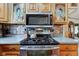 A modern kitchen showcases stainless steel appliances, including a stove and microwave, set against a decorative backsplash at 5750 W 650 N, Thorntown, IN 46071