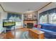 Cozy living room featuring a brick fireplace, wood floors, and a large screen TV at 5750 W 650 N, Thorntown, IN 46071