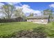 Large backyard featuring lush green grass, mature trees, and a brick home at 6231 W Clinton St, Stilesville, IN 46180