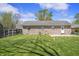 Well-maintained backyard with grass, brick home, mature trees, and a concrete patio at 6231 W Clinton St, Stilesville, IN 46180