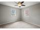 Cozy bedroom with neutral tones, two windows, ceiling fan, and plush carpet flooring at 6231 W Clinton St, Stilesville, IN 46180