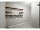 Laundry room with grey walls, featuring wooden shelves for storage and washer/dryer hookups at 6231 W Clinton St, Stilesville, IN 46180