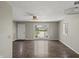 Spacious living room with hard wood floors, a ceiling fan, and a large window offering expansive views of the front yard at 6231 W Clinton St, Stilesville, IN 46180