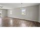 Open living room featuring hard wood floors, two windows offering exterior views, and neutral paint throughout at 6231 W Clinton St, Stilesville, IN 46180