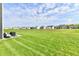 Expansive backyard with lush green grass and a serene view of neighboring homes and pond at 6398 Marden Trl, Brownsburg, IN 46112