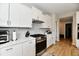 Modern kitchen featuring white cabinets, quartz countertops, stainless steel appliances, and wood-look flooring at 6398 Marden Trl, Brownsburg, IN 46112