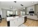 Open-concept living room with kitchen island, pendant lights, and cozy seating area by the fireplace at 6398 Marden Trl, Brownsburg, IN 46112