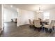 Well-lit dining room with gray wood flooring, seating for six, and an elegant chandelier at 6559 Ambrosia Ln, Pendleton, IN 46064
