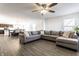 Open-concept living room with gray wood flooring, sectional sofa, and ample natural light at 6559 Ambrosia Ln, Pendleton, IN 46064