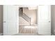 View through double doors to a bright entryway with wood-look floors and a staircase at 657 Kilmore Dr, Pendleton, IN 46064