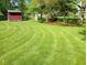 Expansive backyard features a large shed with manicured green lawn, and mature trees at 7017 Mc Lain Dr, Indianapolis, IN 46217