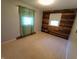 Bedroom with light carpet features wood accent wall and window with bright light at 7017 Mc Lain Dr, Indianapolis, IN 46217