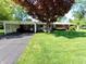 Charming single-story brick home with mature trees, manicured lawn, and a covered carport at 7017 Mc Lain Dr, Indianapolis, IN 46217