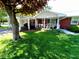 Comfortable front porch and carport next to a beautifully landscaped lawn at 7017 Mc Lain Dr, Indianapolis, IN 46217