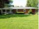 Brick single-story home featuring a covered parking area and landscaped front yard at 7017 Mc Lain Dr, Indianapolis, IN 46217