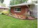 Charming brick home with well-maintained landscaping, including a birdhouse and colorful shrubs and mulch at 7017 Mc Lain Dr, Indianapolis, IN 46217