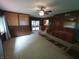 Living room showing wood paneling, ceiling fan, and access to sunroom and kitchen at 7017 Mc Lain Dr, Indianapolis, IN 46217
