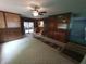 Living room with wood paneling, ceiling fan, and open access to the sunroom and kitchen at 7017 Mc Lain Dr, Indianapolis, IN 46217