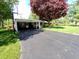 Paved driveway leading to a covered parking area of a well-kept brick home at 7017 Mc Lain Dr, Indianapolis, IN 46217