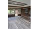 Bright sunroom featuring brick accent wall, wood-beam ceiling, and modern gray flooring at 7017 Mc Lain Dr, Indianapolis, IN 46217
