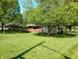 Expansive, well-maintained lawn showcases this brick ranch home with covered carport and mature shade trees at 7017 Mc Lain Dr, Indianapolis, IN 46217