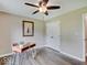 Bedroom featuring a modern ceiling fan, wood-look floors, and a simple desk at 710 Marie Ln, Fortville, IN 46040
