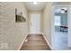 Hallway with wood-look floors, brick wall art, and doorway to a naturally lit room at 710 Marie Ln, Fortville, IN 46040