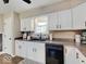 Updated kitchen with a black dishwasher, white cabinets and modern countertops and fixtures at 710 Marie Ln, Fortville, IN 46040