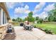 Backyard patio with table and chairs overlooking a green lawn, garden, and shed at 7135 Lantern Rd, Indianapolis, IN 46256