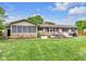 Spacious backyard features stone accents, a screened-in porch, and a well-manicured lawn at 7135 Lantern Rd, Indianapolis, IN 46256