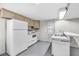 Basement kitchen with white appliances, cabinets, and a sink area under fluorescent lighting at 7135 Lantern Rd, Indianapolis, IN 46256