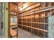 Unfinished storage space in basement with wooden shelves, exposed beams, and a concrete floor at 7135 Lantern Rd, Indianapolis, IN 46256