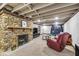Basement area featuring stone fireplace, recreational trampoline, and cozy furnishings at 7135 Lantern Rd, Indianapolis, IN 46256