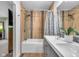 Updated bathroom featuring a double sink vanity, tiled shower and wood look flooring at 7135 Lantern Rd, Indianapolis, IN 46256