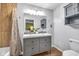 Bathroom with a double sink vanity, wood-look floor, and a shower with decorative tile walls at 7135 Lantern Rd, Indianapolis, IN 46256