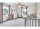 Neutral Bedroom features a crib, giraffe toy, dresser, ceiling fan, and windows for natural light at 7135 Lantern Rd, Indianapolis, IN 46256