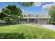Charming single-story home with a lush green lawn, mature tree, and inviting covered front porch at 7135 Lantern Rd, Indianapolis, IN 46256