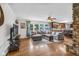 Cozy living room featuring hardwood floors, a stone fireplace, and an adjacent kitchen area at 7135 Lantern Rd, Indianapolis, IN 46256