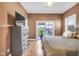 Cozy bedroom featuring hardwood floors, a ceiling fan, and a large window letting in plenty of natural light at 715 Terrace Ave, Indianapolis, IN 46203