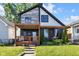 A beautiful two-story home with a wooden porch and a green lawn at 715 Terrace Ave, Indianapolis, IN 46203
