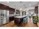 This kitchen boasts stainless steel appliances, an island with seating, and hardwood floors throughout the house at 715 Terrace Ave, Indianapolis, IN 46203