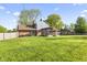 Expansive backyard with green lawn, mature trees, patio, and fenced perimeter at 7153 N Audubon Rd, Indianapolis, IN 46250