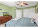 Green bedroom features a ceiling fan, wooden dresser, and TV for a comfortable space at 7153 N Audubon Rd, Indianapolis, IN 46250