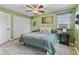 A cozy bedroom featuring green walls, a ceiling fan, and spacious closet at 7153 N Audubon Rd, Indianapolis, IN 46250