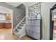 Entryway with staircase, gray dresser, and decorative wall art, next to a glimpse into the kitchen at 7153 N Audubon Rd, Indianapolis, IN 46250