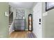 Entryway with staircase, gray dresser, decorative mirror and light green walls with wood-look flooring at 7153 N Audubon Rd, Indianapolis, IN 46250