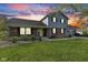 Two-story home features brick and siding, an attached garage, and a well-maintained lawn under a vibrant sky at 7153 N Audubon Rd, Indianapolis, IN 46250
