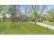 Charming two-story home with landscaped yard and a paved driveway leading to an attached garage at 7153 N Audubon Rd, Indianapolis, IN 46250