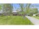 Charming two-story home with landscaped yard and a paved driveway leading to an attached garage at 7153 N Audubon Rd, Indianapolis, IN 46250
