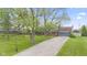 Charming two-story home with landscaped yard and a paved driveway leading to an attached garage at 7153 N Audubon Rd, Indianapolis, IN 46250